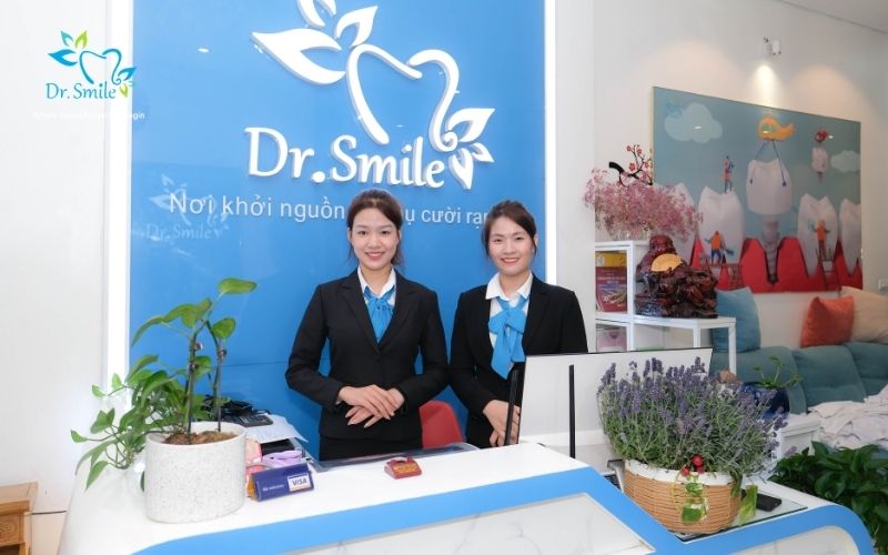 Two smiling receptionists at Dr.Smile dental clinic front desk
