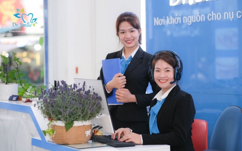 Two smiling receptionists at Dr.Smile dental clinic front desk